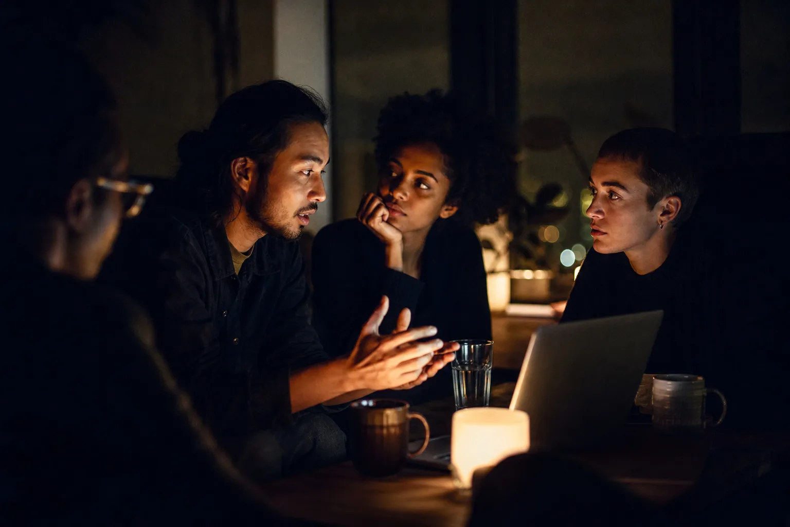 Pertencimento raramente conquistado. Pequeno grupo em conexão intensa numa atmosfera noturna — não pose, conversa real. — A Tribo dos Insanos